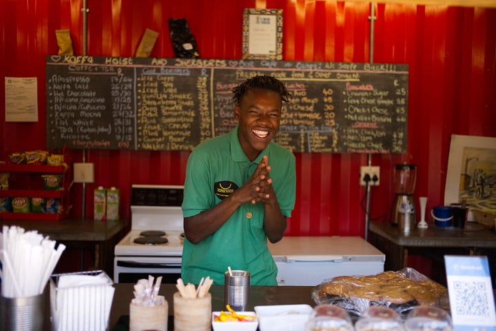 A restaurant worker smiles happily at patrons ordering their food. Photo by Frederik Schweiger on Unsplash