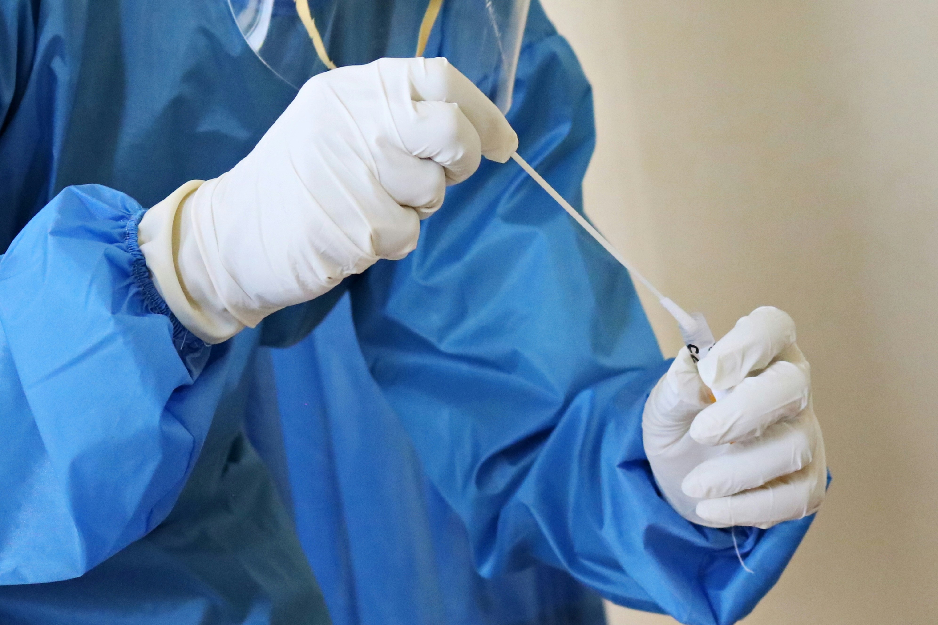 A laboratory worker takes a swab test