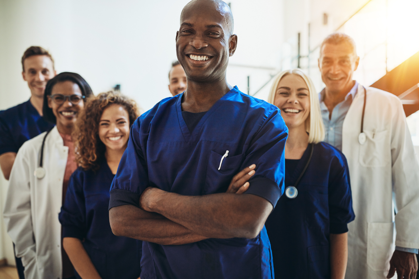 Smiling group of doctors standing in a doctors office welcoming new patients